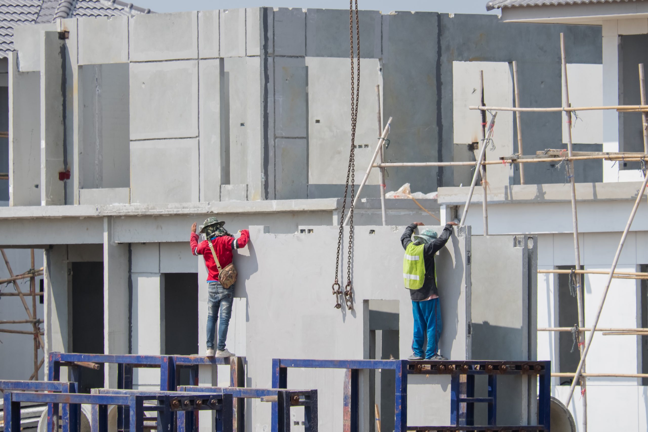 people working construction site against building scaled